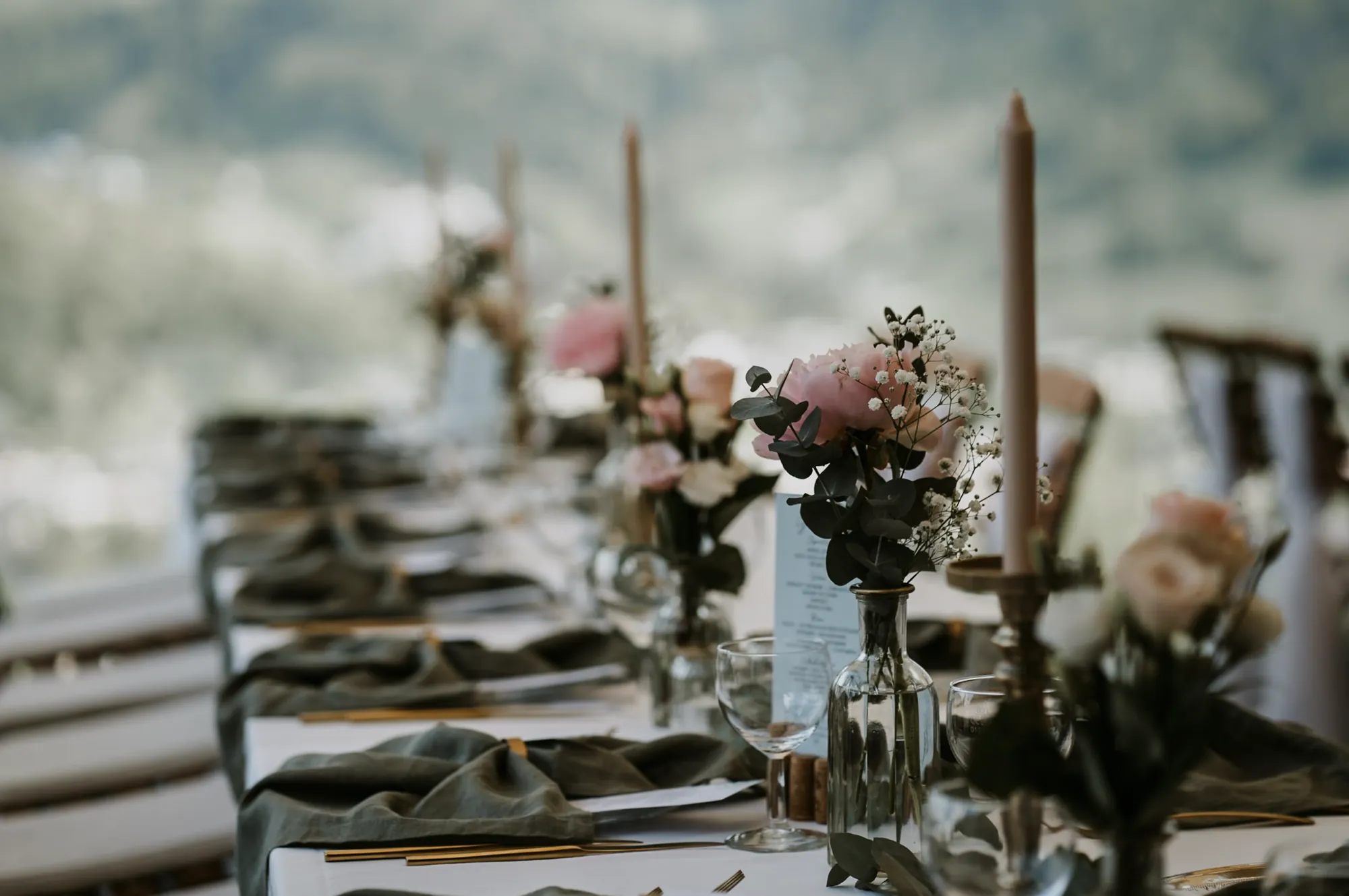Kerzen und Blumen auf der festlich gedeckten Tafel