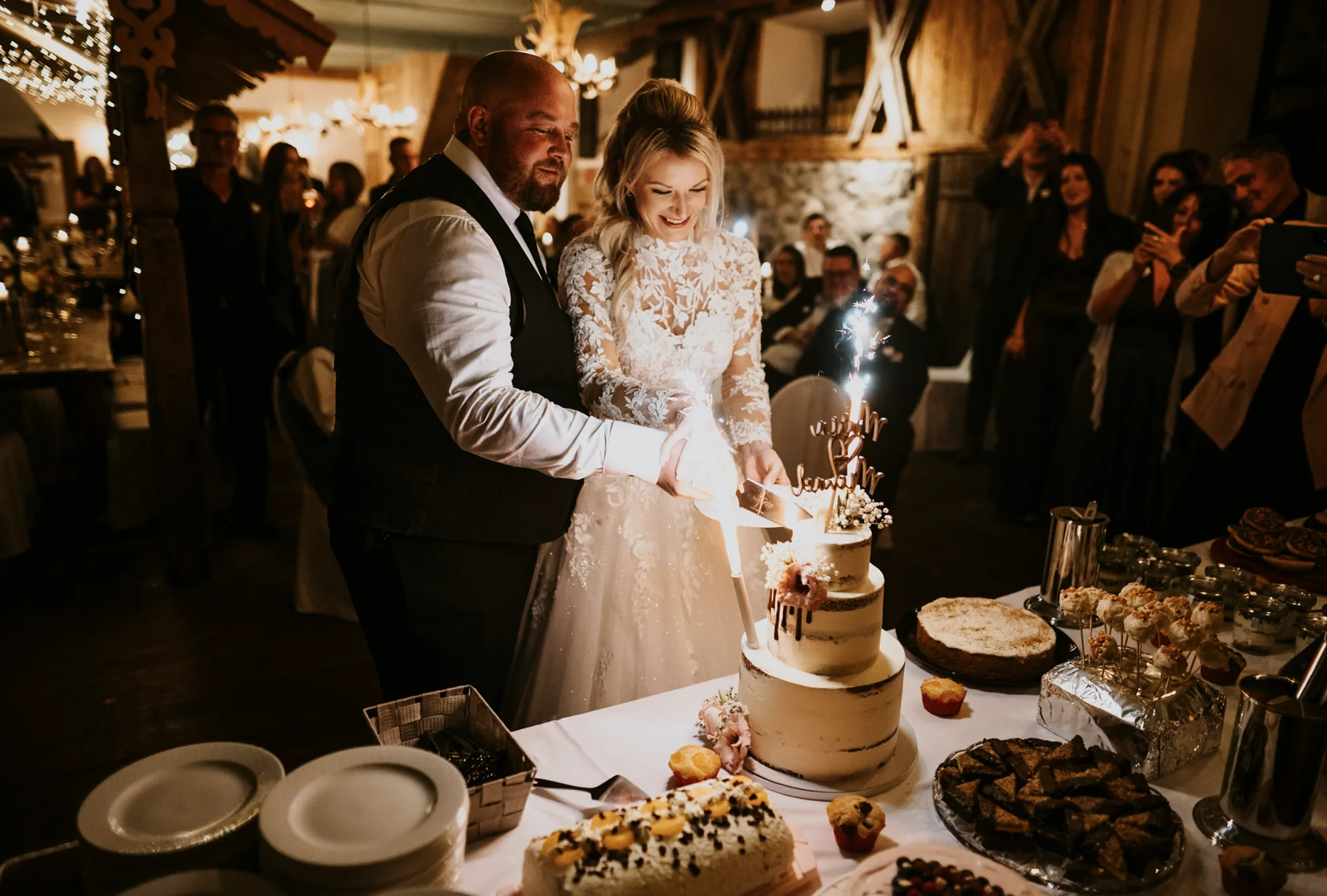 Brautpaar schneidet gemeinsam die Hochzeitstorte an