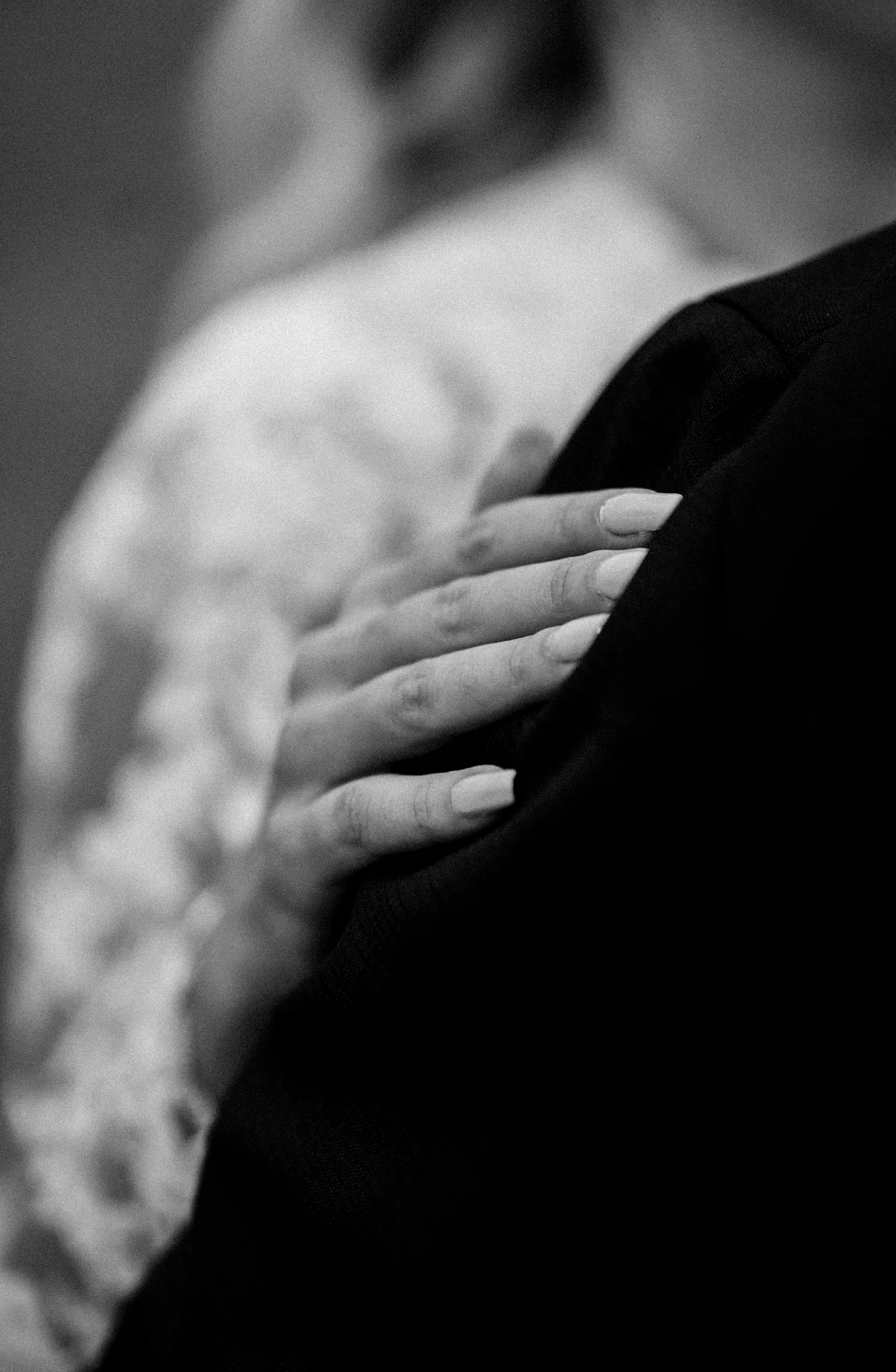 Der Bräutigam legt zärtlich die Hand auf die Schulter der Braut