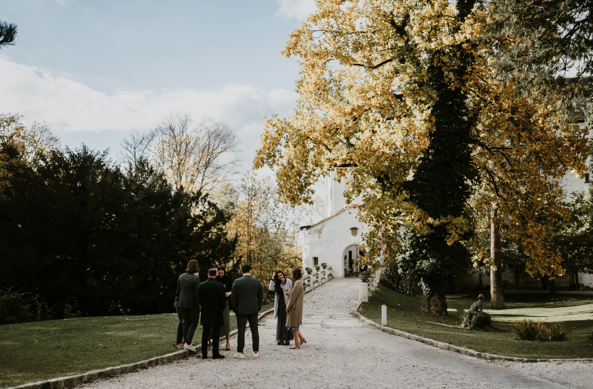 Gäste gehen den herbstlichen Weg hinauf zum Schloss Amerang