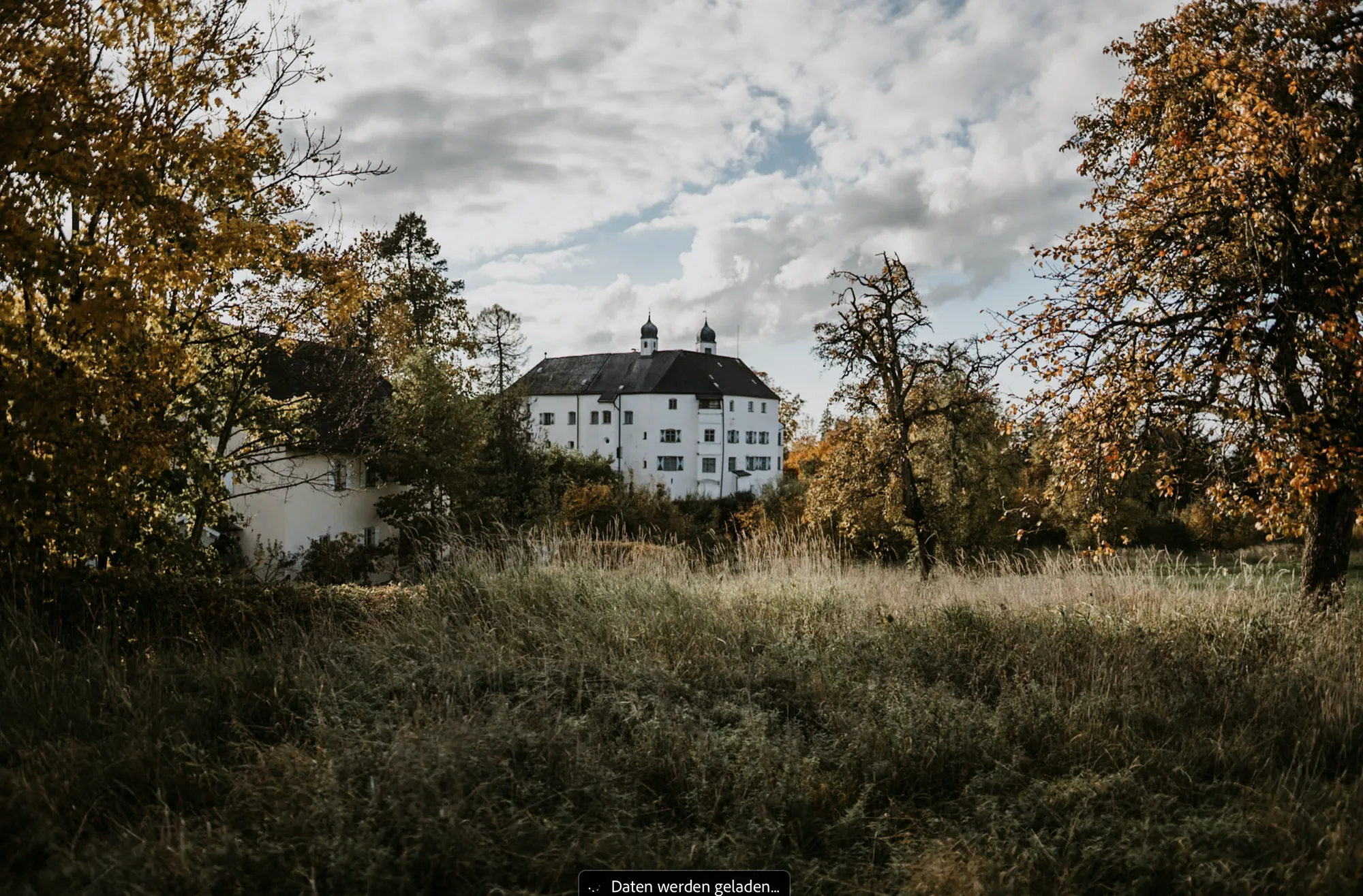 Schloss Amerang mit weitläufiger herbstlicher Wiese